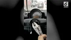 Seorang pria menyetir menggunakan tang, ia memanfaatkannya sebagai handling mobil.