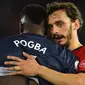 Striker Southampton, Manolo Gabbiadini, menghibur gelandang Manchester United, Paul Pogba, usai laga Premier League di Stadion St Mary, Manchester, Sabtu (1/12). Kedua klub bermain imbang 2-2. (AFP/Glyn Kirk)