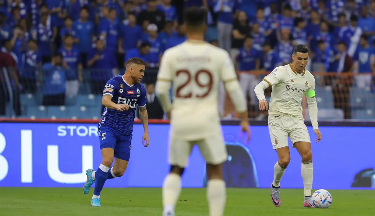 Pemain Al-Nassr, Cristiano Ronaldo, berusaha melewati pemain Al-Hilal pada laga Liga Arab Saudi 2022/202 di Stadion King Fahd, Rabu (19/4/2023). (Twitter Al-Nassr)
