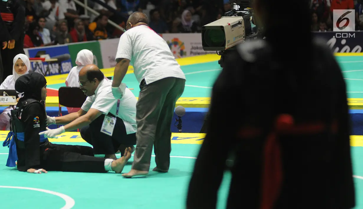 Pesilat Indonesia Pipiet Kamelia mengalami sakit saat bertanding melawan A Janejira dari Thailand pada semifinal kelas D 60kg-65kg putri Asian Games 2018 di Padepokan Pencak Silat, TMII, Jakarta (26/8). Pipiet melaju ke final. (Merdeka.com/Arie Basuki)