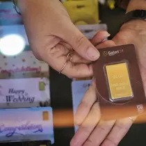 Pegawai menunjukkan emas batangan di Galeri 24, Jakarta, Selasa (13/9/2022). Harga jual kembali (buyback) emas Antam ikut naik Rp 3.000, dibanderol Rp 823.000 per gram. (Liputan6.com/Angga Yuniar)
