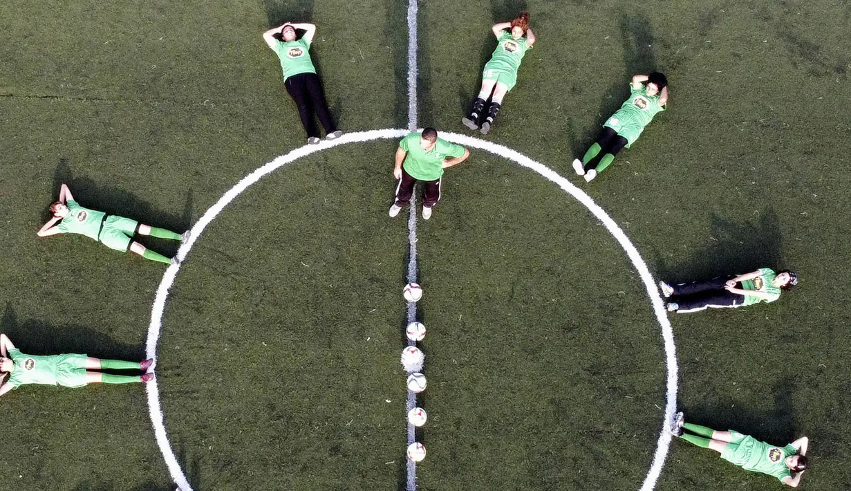 Pelatih pesepak bola putri klub Beit Umar Palestina, Mahmud Musleh, memberikan arahan kepada anak asuhnya saat sesi latihan di sebuah lapangan di Kota Hebron. (AFP/Hazem Bader)