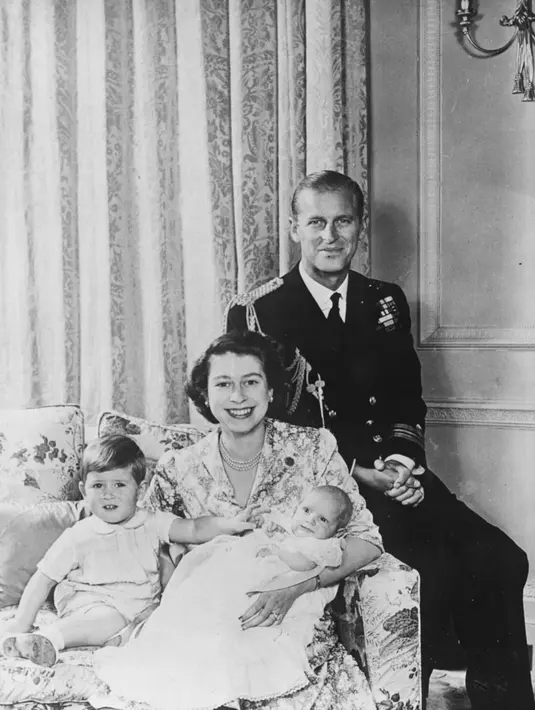 Prince Charles berpose dengan Princess Anna yang saat itu masih berusia 2 bulan. Ia berada di dekapan Princess Elizabeth dan Prince Phillip. Foto ini diambil pada 1950. (Cosmopolitan)