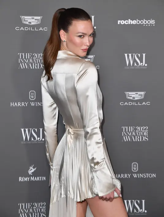 Karlie Kloss menghadiri WSJ. Magazine 2022 Innovator Awards di Museum of Modern Art, New York City, Amerika Serikat, 2 November 2022. Karlie memamerkan kakinya yang panjang dan kencang dalam rok tinggi-rendah berwarna sampanye, sementara Rambut panjangnya dikuncir rapi menjadi kuncir kuda yang jatuh di belakangnya. (ANGELA WEISS/AFP)