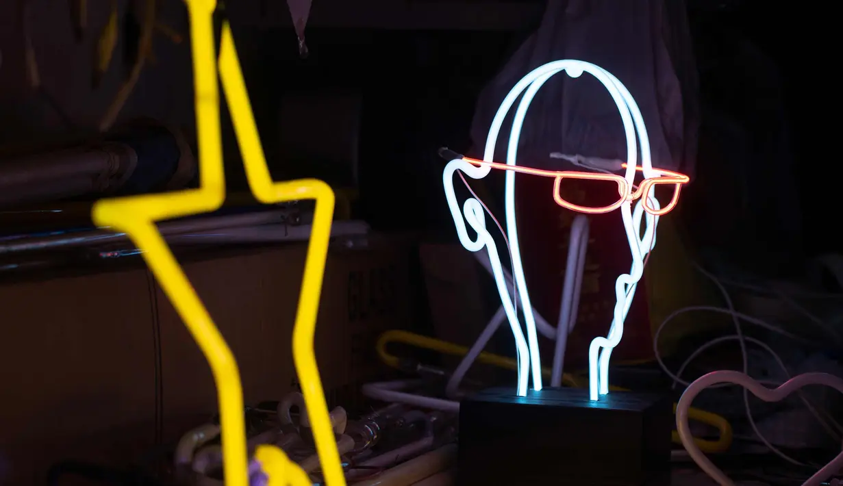 Salah satu karyanya Wu Chi-kai terlihat selama wawancara dengan AFP di Hong Kong (16/4). Wu Chi-kai merupakan salah satu pengrajin neon sign yang tersisa dari jenisnya di Hong Kong. (AFP Photo/Philip Fong)