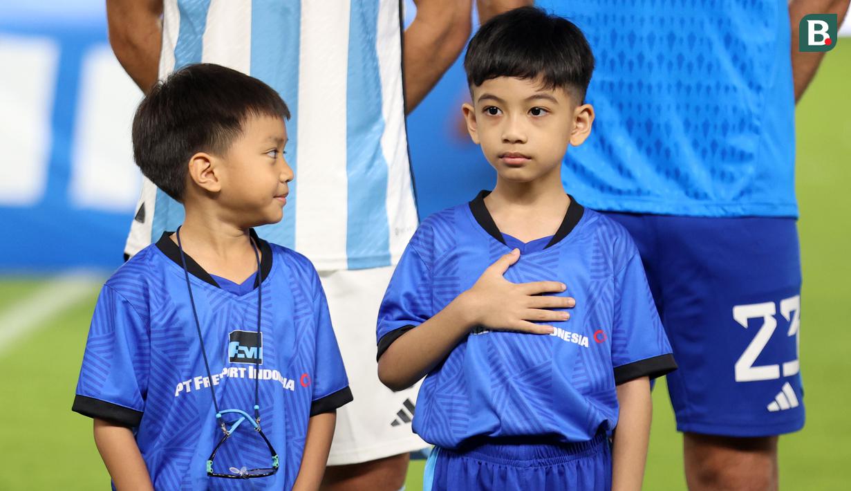 Cucu Presiden RI Joko Widodo, Jan Ethes (kanan) saat menjadi player escort pemain Timnas Argentina pada laga FIFA Matchday melawan Timnas Indonesia di Stadion Utama Gelora Bung Karno (SUGBK), Senayan, Jakarta, Senin (19/06/2023). (Bola.com/Bagaskara Lazuardi)