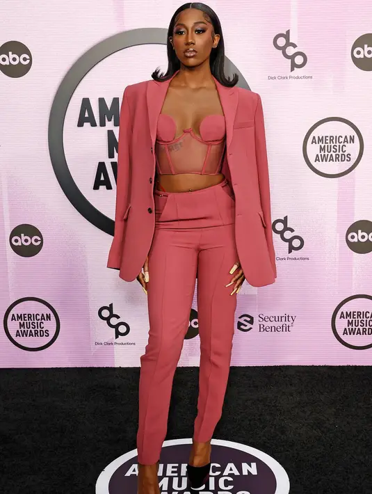 <p>Flo Milli anggun menawan dalam setelan blazer dan celana bernuansa merah muda. Blazernya ia sampirkan di pundak menutupi dalaman lingerie yang juga berwarna senada. Foto: Vogue.</p>