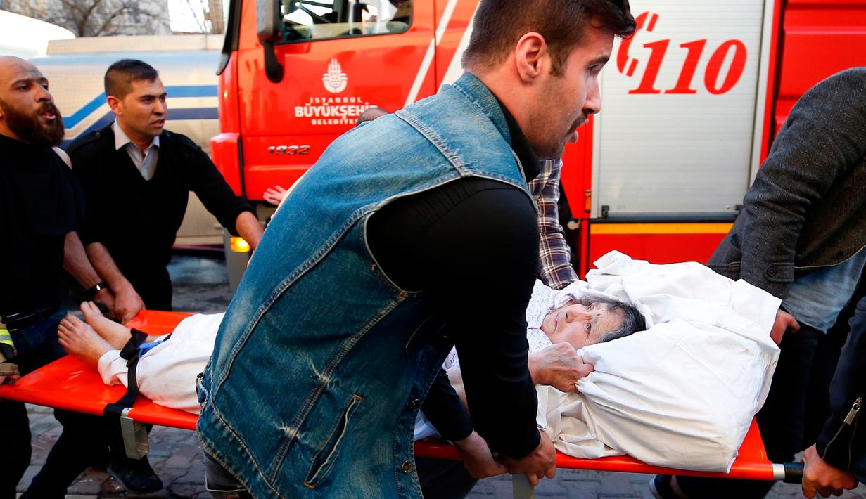 Petugas medis dibantu warga mengevakuasi seorang pasien setelah terjadi kebakaran di rumah sakit di distrik Gaziosmanpasa, Istanbul, Turki (5/4). Sebanyak 70 pasien dievakuasi dari peristiwa ini. (AP Photo/ Emrah Gurel)