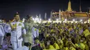 Raja Maha Vajiralongkorn dan Ratu Suthida melambaikan tangan ke pendukungnya di Bangkok, Thailand, Minggu (1/11/2020). Di bawah tekanan yang meningkat dari pengunjuk rasa yang menuntut reformasi pada monarki, Raja dan Ratu Thailand bertemu dengan ribuan pendukungnya. (AP Photo/Wason Wanichakorn)