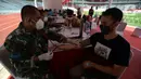 Aparat TNI memeriksa kondisi warga saat vaksinasi COVID-19 gratis di Stadion Gelora Bung Karno (GBK), Jakarta, Sabtu (26/6/2021). Vaksinasi dilakukan secara massal bagi warga ber-KTP DKI Jakarta. (merdeka.com/Imam Buhori)