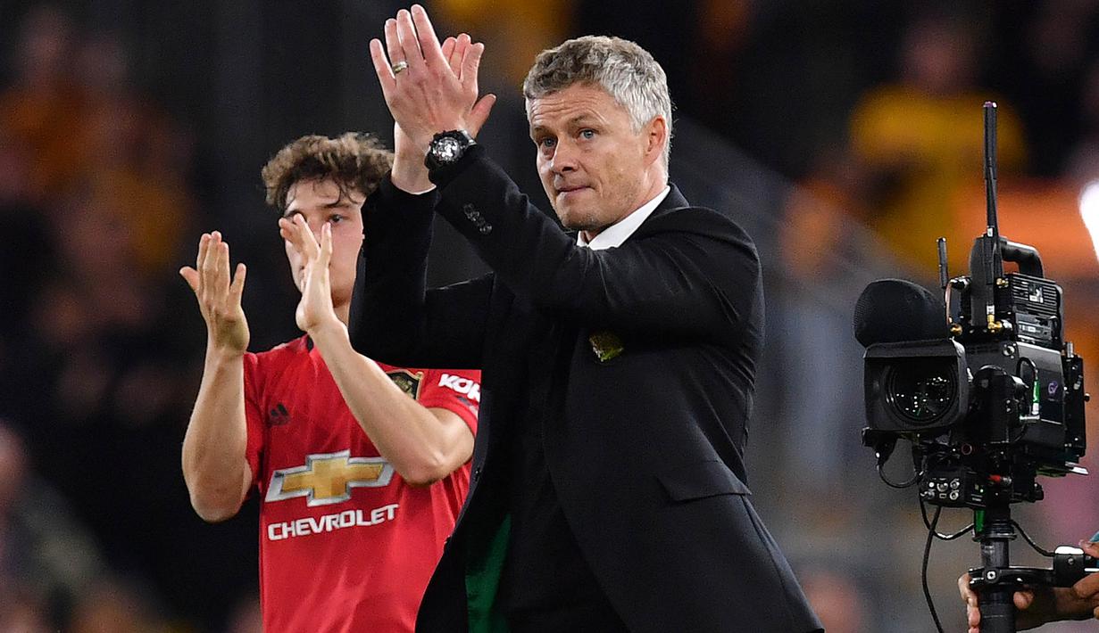 Pelatih Manchester United, Ole Gunnar Solskjaer, menyapa suporter usai melawan Wolverhampton pada laga Premier League di Stadion Molineux, Wolverhampton, Senin (19/8). Kedua klub bermain imbang 1-1. (AFP/Paul Ellis)