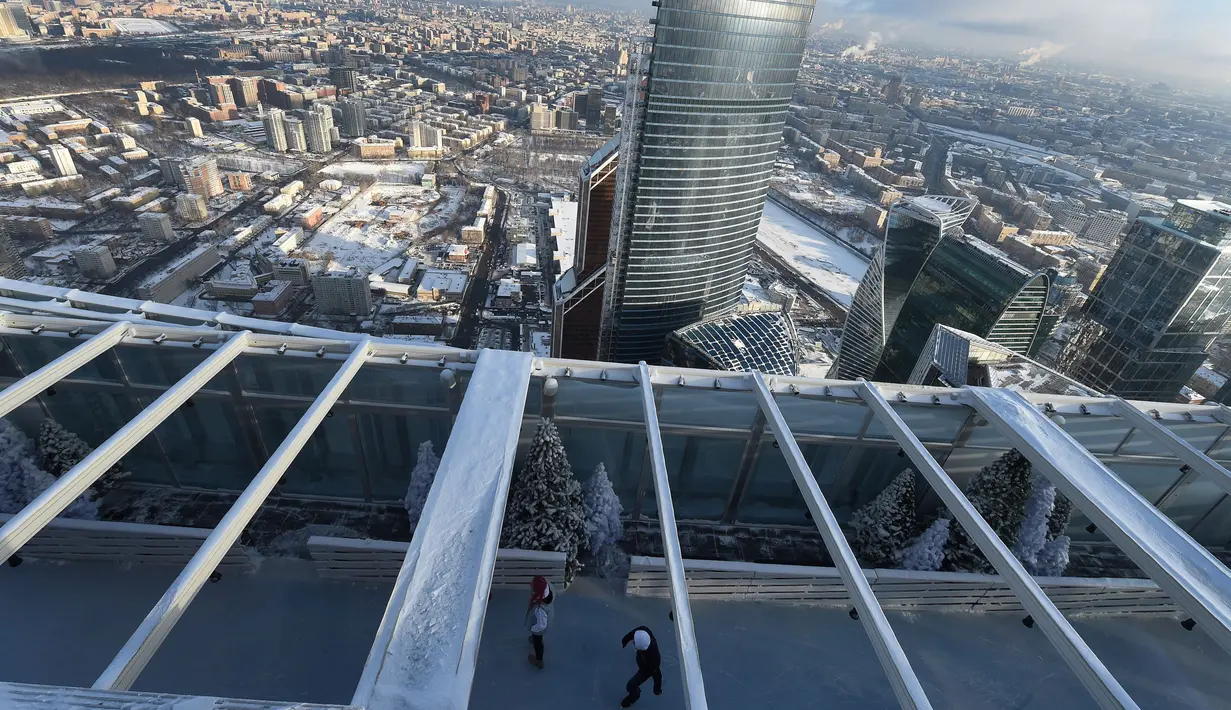 Sepasang pengunjung menikmati kebersamaan bermain ice skating di arena ski lantai teratas pusat bisnis Oko Tower di Moskow, Kamis (15/12). Arena ski yang berada di ketinggian 354 meter ini diklaim menjadi yang tertinggi di Eropa. (REUTERS/Maxim Shemetov)