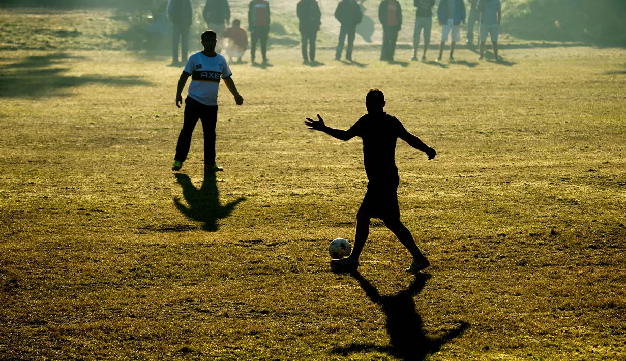 Pengungsi bermain bola dekat barak militer di Ehra-Lessien dekat Wolfsburg, Jerman, Selasa (3/11/205).  AFP Photo/DPA/Julian Stratenschulte)