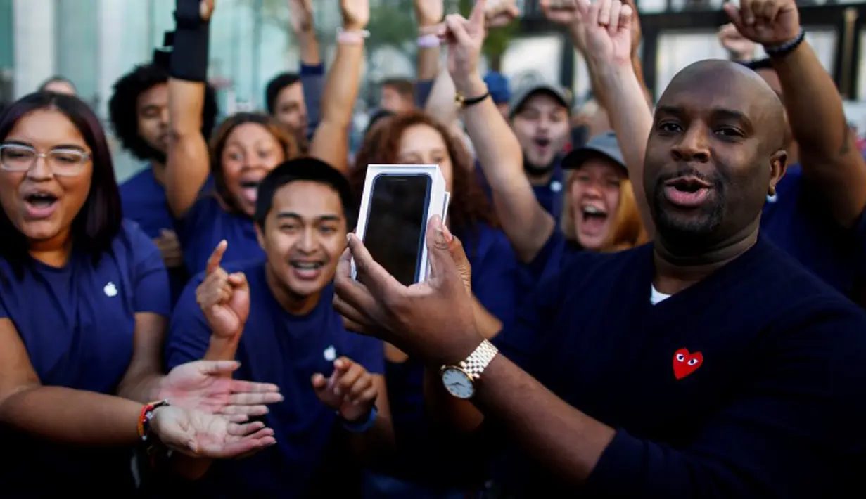 Pelanggan merayakan keberhasilannya mendapatkan iPhone 7 dengan pekerja Apple di sebuah toko Apple Inc di New York, AS, Jumat (16/9). Pembeli iPhone7 hari ini menjadi bagian dari pembeli pertama di seluruh dunia. (REUTERS / Eduardo Munoz)