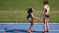 Pelari Selandia Baru, Nikki Hamblin (kanan), menolong pelari Amerika Serikat, Abbey D'Agostino (kiri), pada babak penyisihan atletik nomor 5.000 meter putri Olimpiade Rio de Janeiro, Selasa (16/8/2016). (AFP/Johannes Eisele)