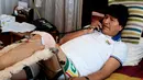 Presiden Bolivia, Evo Morales mengenakan perban pada kakinya sambil menerima telpon usai menjalani fisioterapi di kediamannya di La Paz, Bolivia, (30/6). Evo Morales memang dikenal sebagai penggila olahraga sepak bola. (REUTERS/David Mercado)