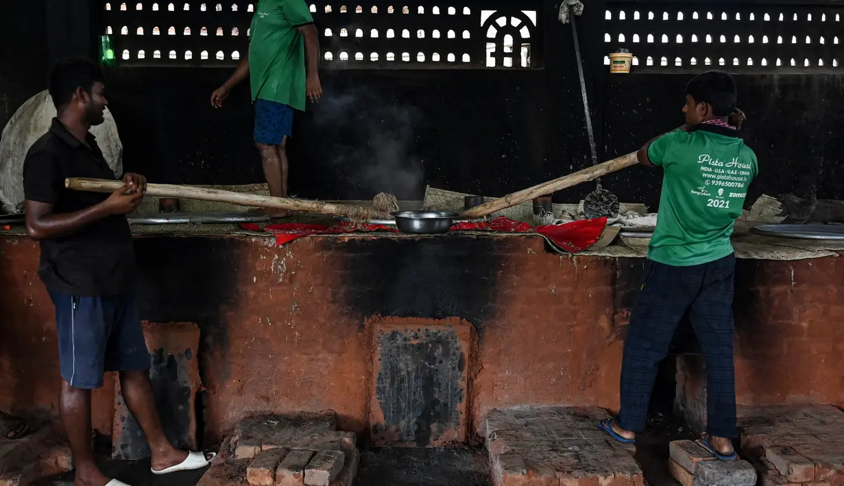 Koki katering menyiapkan hidangan bernama 'rebusan daging kambing Haleem' dalam peralatan besar untuk dijual kepada umat Muslim untuk berbuka puasa selama Ramadhan di Chennai (20/4/2022). Haleem adalah sajian favorit yang cukup populer, terutama saat bulan Ramadhan dan Muharram. (AFP/Arun Sankar)