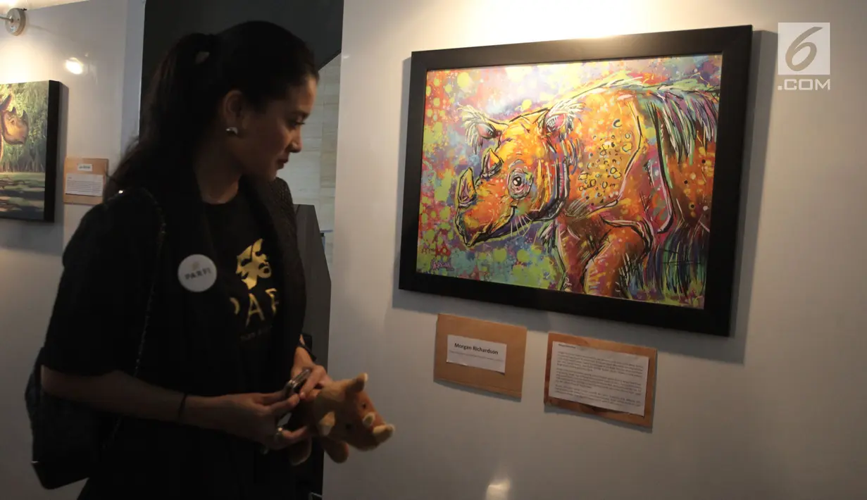 Artis Marcella Zalianty saat melihat karya dalam pameran seni badak Sumatera di Perpustakaan Nasional Indonesia, Jakarta Pusat, Jumat (19/1). Pameran ini bertajuk 'Harta Karun Tersembunyi Indonesia'. (Liputan6.com/Arya Manggala)