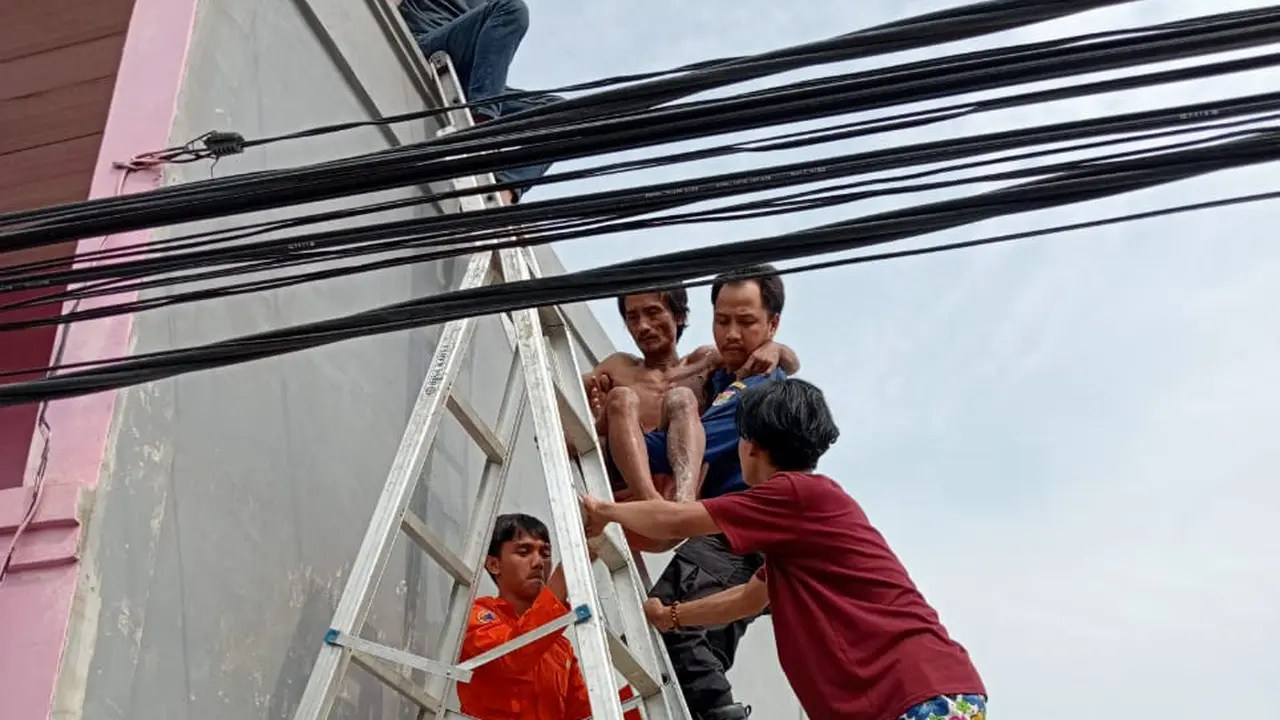 Seorang pria tersetrum saat hendak membantu memperbaiki atap tetangganya di Kosambi, Kabupaten Tangerang, Jumat (22/7/2022) (Liputan6.com/Pramita Tristiawati)