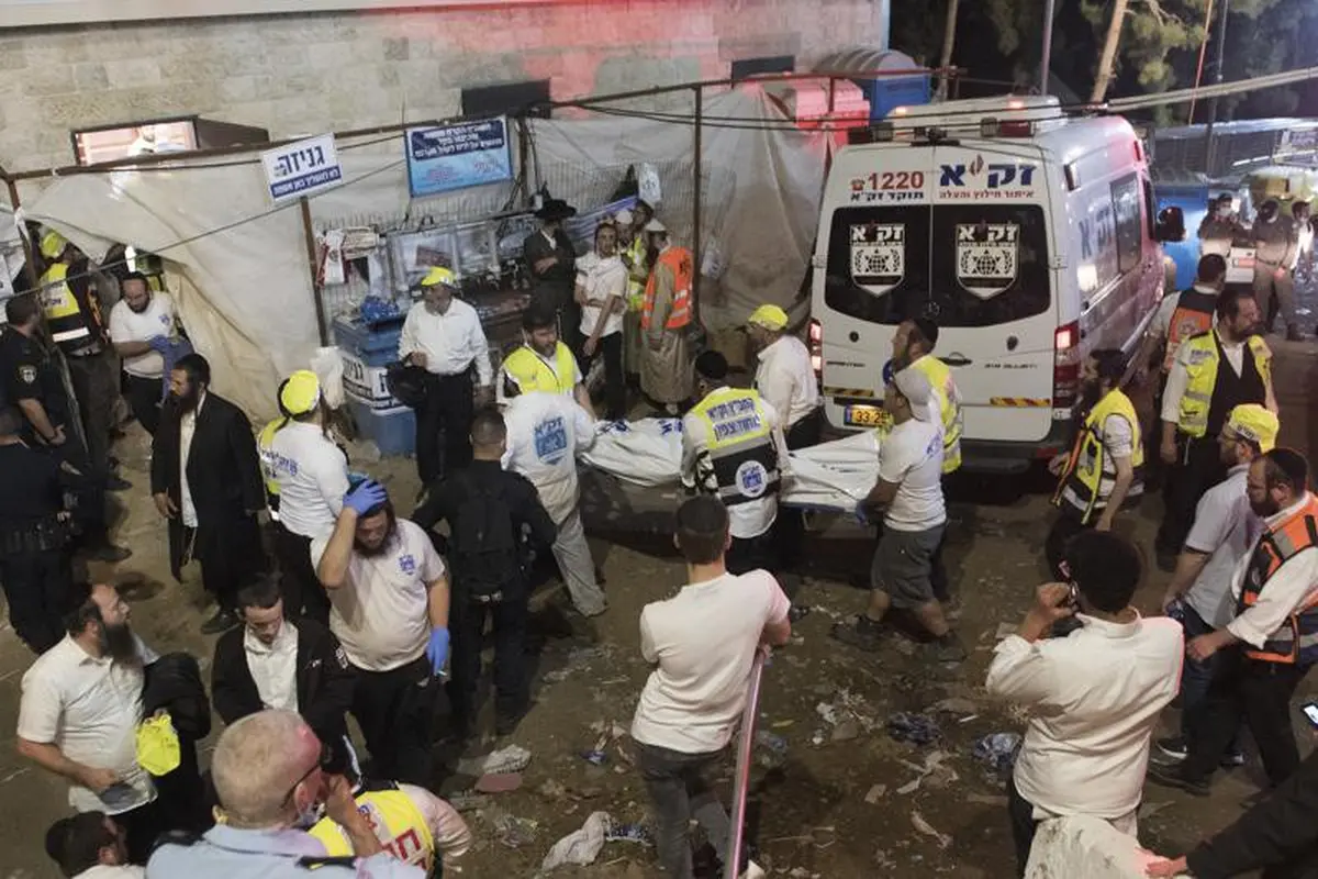 Pejabat keamanan dan penyelamat Israel membawa tubuh korban yang meninggal selama perayaan Lag Ba'Omer di Mt. Meron di Israel utara, Jumat, 30 April 2021. (Foto: AP)
