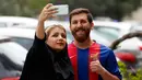 Pemuda asal Iran, Reza Parastesh berswafoto dengan seorang penggemar di sebuah jalan di Teheran, Senin (8/5). Reza Parastesh harus dibawa ke kantor polisi akhir pekan lalu gara-gara terlalu mirip dengan bintang Barcelona, Lionel Messi. (ATTA KENARE/AFP)