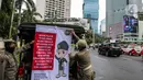Petugas Satpol PP memasang spanduk mini untuk memberikan imbauan sekaligus sosialisasi kepada masyarakat guna mencegah penularan Covid-19 di Bundaran HI, Jakarta, Kamis (19/3/2020). (Liputan6.com/Faizal Fanani)