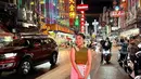 Berpose di China Town, pelantun ‘Terlukis Indah’ itu tampil keren dengan padanan cut out top warna hijau cerah, pencil skirt, sneakers, dan shoulder bag.  [Foto: IG/zivamagnolya].