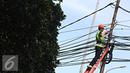 Pekerja mengecek instalasi kabel di tiang listrik milik PLN, Jakarta, Jumat (26/2). PLN menjaga mutu keandalan penyaluran tenaga listrik, memenuhi ketentuan keselamatan ketenagalistrikan, dan estetika tata kota Jakarta. (Liputan6.com/Immanuel Antonius)