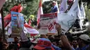 Peserta demo menunjukan poster saat menggelar aksi unjuk rasa di depan kantor Kementerian BUMN, Jakarta, Senin (31/7). (Liputan6.com/Faizal Fanani)