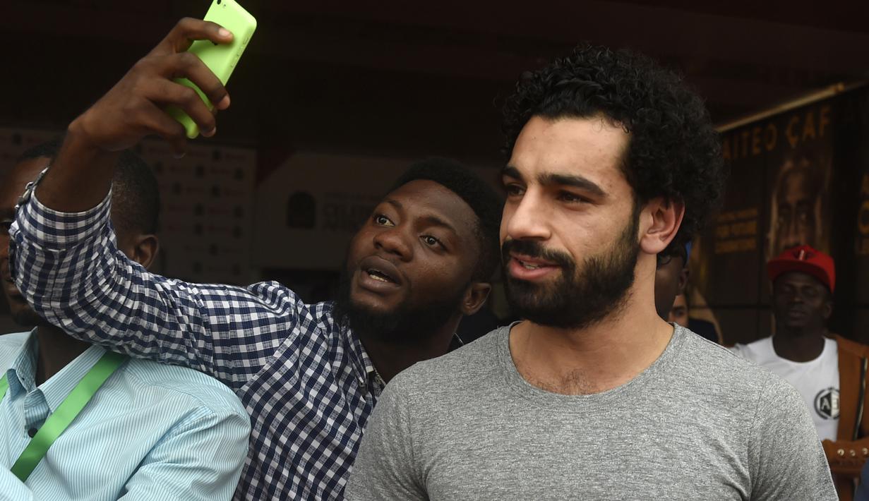 Seorang fans melakukan foto selfie dengan Mohamed Salah sebelum CAF Awards di Accra International Press Conference, Accra, (4/1/2018). Salah mengalahkan Sadio Mane dan Pierre-Emerick Aubameyang. (AFP/Pius Utomi Ekpei)