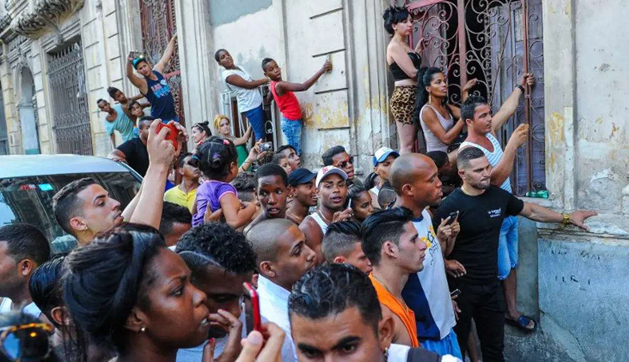 Sejumlah penggemar berdesak-desakan untuk melihat penyanyi kesayangannya Rihanna saat melakukan sesi foto di restoran La Guarida, Havana, Kuba, (28/5/2015). (AFP PHOTO/Yamil LAGE)