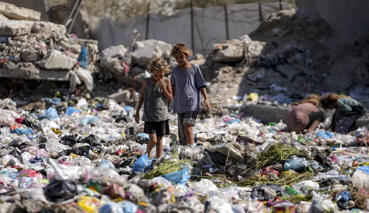 Anak-anak pengungsi memilah-milah sampah di sebuah jalan di Deir al-Balah, Jalur Gaza tengah pada 29 Agustus 2024. (AP Photo/Abdel Kareem Hana)