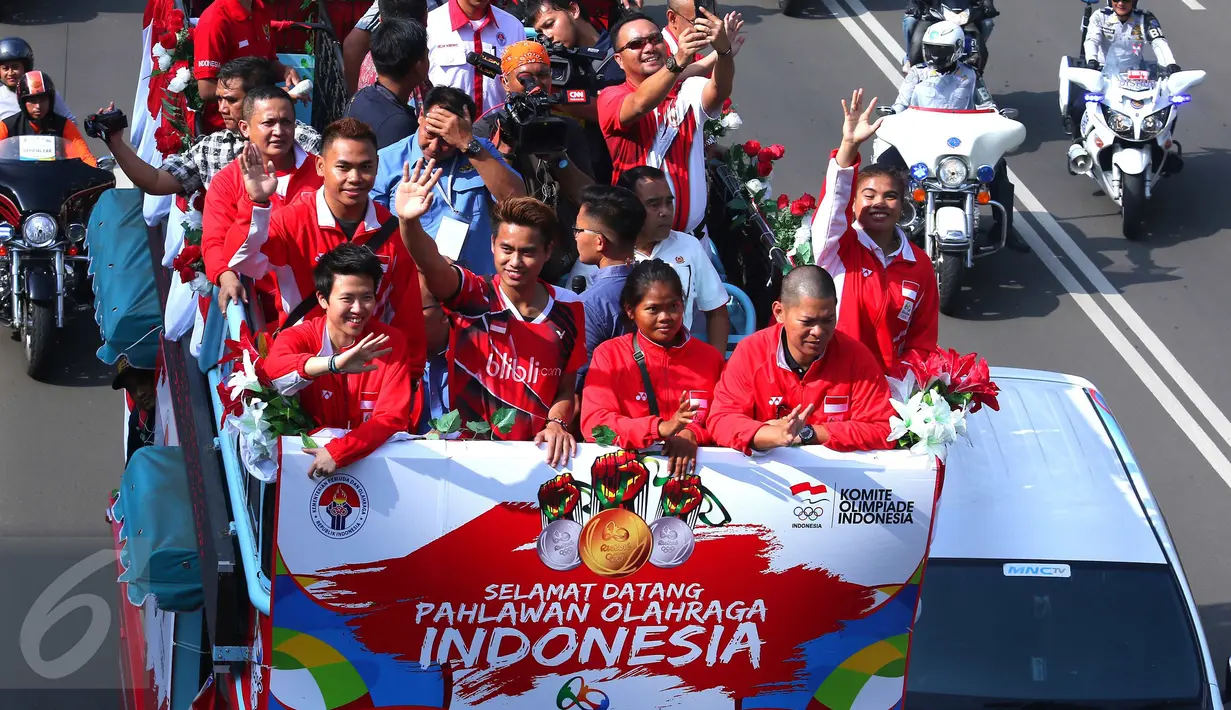 Atlet Indonesia peraih medali Olimpiade Rio 2016 yang ikut dalam arak-arakan terlihat melambaikan tangan saat melintas menuju Istana Negara, Jakarta, Rabu (24/8). Arak-arakan ini dikawal puluhan pengendara motor gede alias Moge (Liputan6.com/Angga Yuniar)