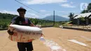 Buruh tani membawa karung berisi gabah di kawasan Tanjung Sari, Kabupaten Bogor, Jawa Barat, Senin (14/3/2022). Sejak sepekan terakhir, harga gabah kering giling di tingkat petani naik dari Rp 4.400 menjadi Rp 4.600 per kilogram. (merdeka.com/Arie Basuki)