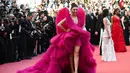 Ia tampil cantik dengan dua gaun yang berbeda. Yang pertama, ia mengenakan gaun warna pink. Gaun ini memamerkan belahan dada dan kakinya yang indah. (AFP/Anne-Christine POUJOULAT)