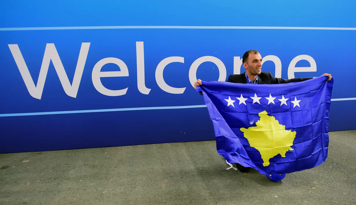 Seorang delegasi sepak bola Kosovo berfoto dekat tulisan selamat datang  saat merayakan diterimnya Kosovo sebagai anggota UEFA pada kongres UEFA ke-40 tahun di Hungexpo Fair Center, Budapest, Hungary, (3/52016). (AFP/Attila Kisbenedek)