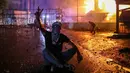 Seorang pengunjuk rasa Lebanon mengacungkan tanda untuk kemenangan saat bentrokan dengan pasukan keamanan dalam sebuah demonstrasi untuk menunjukkan solidaritas kepada warga Gaza di Awkar, sebelah timur Beirut. (JOSEPH EID/AFP)