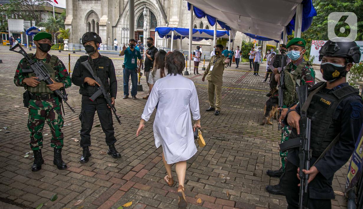 Anggota TNI dan Polisi bersenjata lengkap melakukan penjagaan di depan Gereja Katedral, Jakarta, Kamis (1/4/2021). Sebanyak 150 personel gabungan TNI, Polri dan Satpol PP melakukan pengamanan jelang rangkaian perayaan Hari Paskah di gereja tersebut. (Liputan6.com/Faizal Fanani)