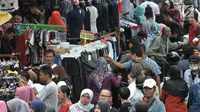 Pengunjung memilih pakaian yang dijajakan pedangang di Pasar Tanah Abang, Jakarta, Minggu (10/6). Mendekati perayaan Idul Fitri 1439 H, pusat grosir terbesar di asia tenggara tersebut semakin riuh oleh pengunjung. (Merdeka.com/Iqbal S. Nugroho)