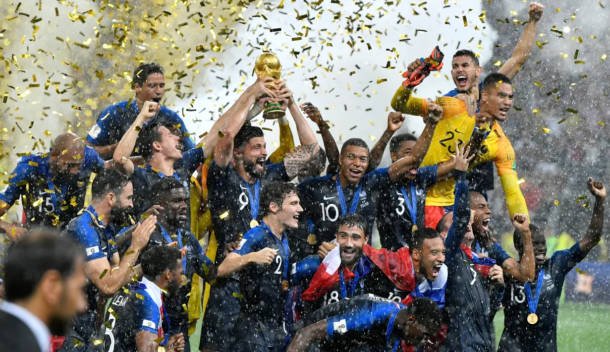 Striker timnas Prancis, Olivier Giroud mengangkat trofi Piala Dunia 2018 saat merayakan gelar juara setelah mengalahkan Kroasia pada  laga final di Luzhniki Stadium, Minggu (15/7). Prancis membekuk Kroasia dengan skor akhir 4-2. (AP Photo/Martin Meissner)
