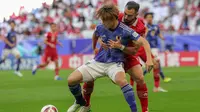 Jordi Amat melakukan pelanggaran kepada Ayase Ueda yang berbuah penalti dalam laga Grup D Piala Asia 2023, Rabu (24/1/2024) malam WIB. (AFP/Giuseppe Cacace)