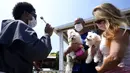 Seorang Fransiskan memberkati anjing peliharaan dalam misa untuk menghormati Santo Fransiskus dari Assisi pada Hari Raya Santo di Brasilia, Brasil, Senin (4/10/2021). Santo Katolik dianggap sebagai pelindung hewan. (AP Photo/Eraldo Peres)