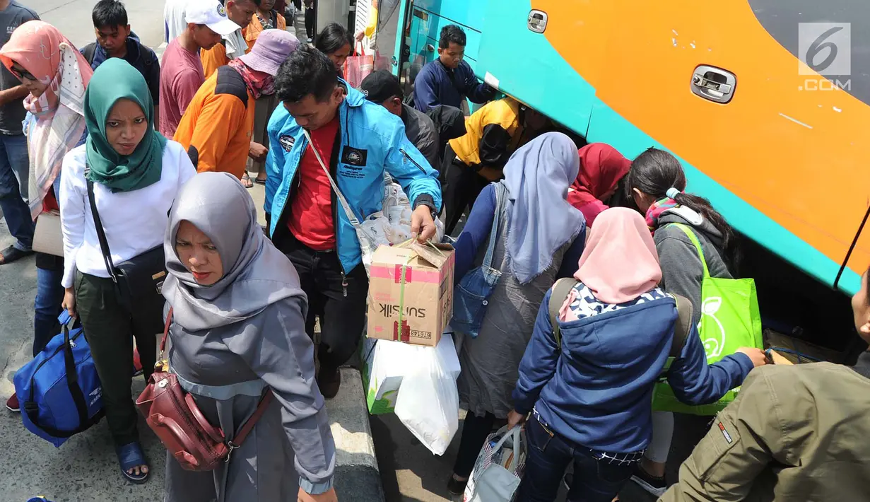Pemudik menurunkan barang bawaan setibanya di Terminal Bus Kampung Rambutan, Jakarta Timur, Minggu (9/6/2019). Hari ini diprediksi menjadi puncak arus balik pemudik di Terminal Kampung Rambutan seiring berakhirnya masa libur Lebaran. (merdeka.com/Arie Basuki)