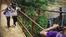 Wisatawan mengabadikan gambarnya di jembatan Air Terjun Temam, Sumatera Selatan, Jumat (10/10/2014) (Liputan6.com/Faizal Fanani)