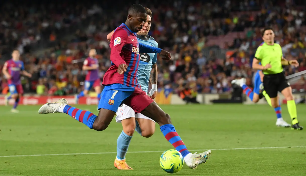 <p>Pemain depan Barcelona Ousmane Dembele (kiri) berebut bola dengan gelandang Celta Vigo Fran Beltran pada laga lanjutan La Liga di Camp Nou, Rabu (11/5/2022) dini hari WIB. Barcelona menghajar Celta Vigo 3-1 di kandang sendiri. (LLUIS GENE / AFP)</p>