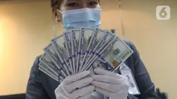 Karyawan bank menunjukkan mata uang dolar Amerika Serikat (AS) di Jakarta, Senin (2/11/2020). Nilai tukar rupiah pada perdagangan Senin (2/11) sore ditutup melemah 0,1 persen ke level Rp14.640 per dolar AS, dari perdagangan sebelumnya yaitu Rp14.690 per dolar AS. (Liputan6.com/Angga Yuniar)