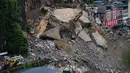 Kendaraan penyelamat bersiaga di jembatan saat tim penyelamat melakukan operasi pencarian dan penyelamatan di lokasi tanah longsor di Kabupaten Pengshui, Chongqing, Tiongkok barat daya, Sabtu, 18 Juli 2026. (AP Photo/Andy Wong)
