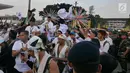 Cawapres 01 Ma'ruf Amin didampingi istrinye Nyai Wury Estu Handayani melempar kaus seusai 'Konser Putih Bersatu' di Stadion GBK, Jakarta, Sabtu (13/4). Pasangan Capres dan Cawapres 01 menggunakan kereta kencana seusai Konser Putih Bersatu menuju lokasi debat. (Liputan6.com/Herman Zakharia)