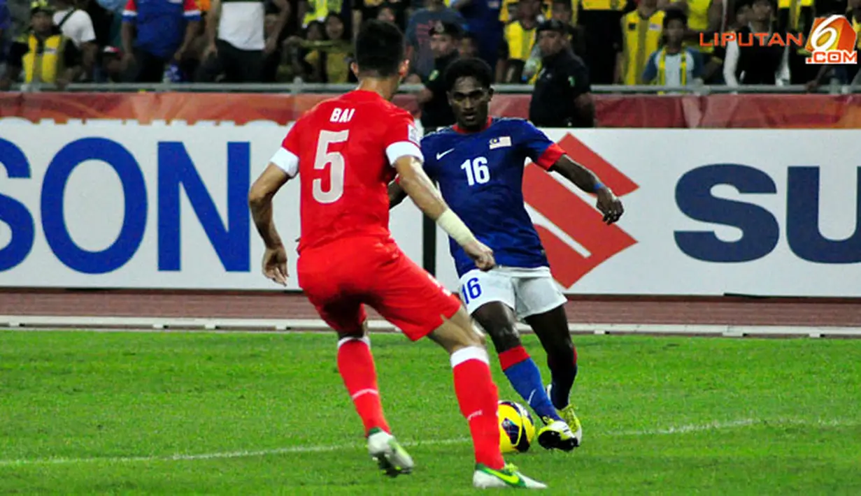 Pemain Malaysia, Kunanlan Subramaniam (kanan) berusaha melewati pemain Singapur, Baihakki Khaizan (kiri) dalam Laga Piala AFF Suzuki 2012 di Stadion Bukit Jalil, Kuala Lumpur, Malaysia, minggu 25 November 2012. pertandingan berakhir 0-3 untuk Singapura.