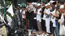 Massa aksi damai 4 November melaksanakan salat Jumat di Jalan Merdeka Barat, Jakarta, Jumat (4/11). Mereka menggelar salat Jumat di belakang pembatas beton dan mobil barakuda yang mengamankan kawasan itu. (Liputan6.com/Faizal Fanani)